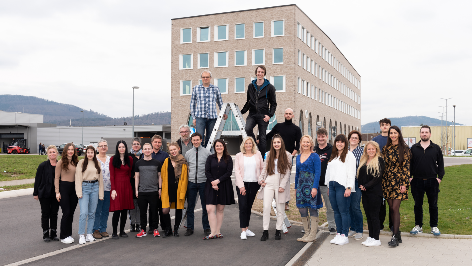 Gruppenbild: Das Team steht vor dem Achteck-Gebäude